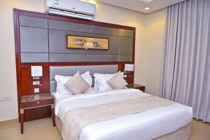 a hotel room with a large bed and a television on the wall at تارا للشقق المخدومة in Riyadh +109 photos