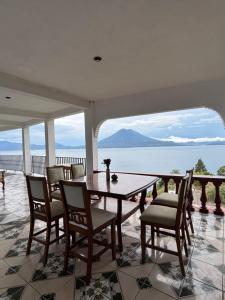 a dining room with a table and chairs and a view of the ocean at Casa Miralagos in Santa Cruz La Laguna