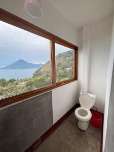 a bathroom with a toilet and a large window at Casa Miralagos in Santa Cruz La Laguna
