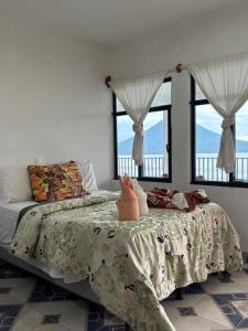 a bedroom with a bed and two windows at Casa Miralagos in Santa Cruz La Laguna +48 photos