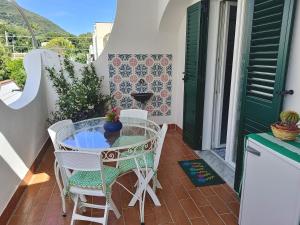 a patio with a table and chairs on a balcony at Villetta Ninì in Ischia Town