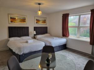 a hotel room with two beds and a table at Kingfield Boutique Hotel in Sheffield
