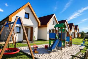 a playground in front of a house at Domki wakacyjne 4 YOU in Ustka