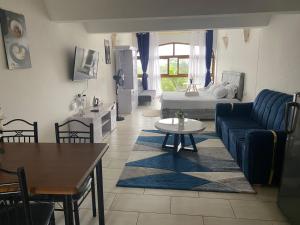 a living room with a blue couch and a table at Ocean view villa in Diani Beach