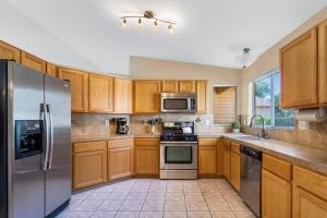 a kitchen with wooden cabinets and stainless steel appliances at Peaceful Valley in Tucson +15 photos