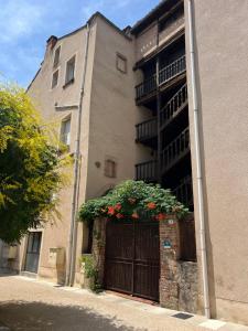 a building with a gate with flowers on it at La Chantrerie Saint Priest in Cahors