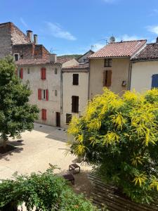 a group of buildings in a courtyard with trees at La Chantrerie Saint Priest in Cahors