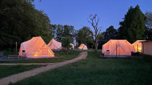 eine Ansammlung von Zelten auf einem Feld mit einem unbefestigten Weg in der Unterkunft Green Glamping in Sønderborg