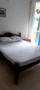a large bed in a room with a window at Casa Branca in Siolim