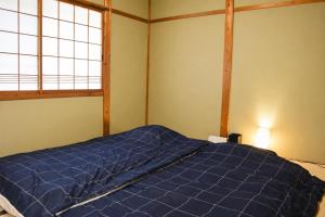 a bedroom with a blue bed with a window at Komorebi/こもれび in Takayama