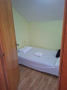 a small bedroom with a bed with white sheets at Apartmani Lazić No 11 in Gracanica