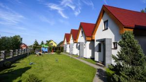 a group of houses with a playground in the yard at Domki wakacyjne 4 YOU in Ustka
