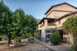a large stone building with a tree in front of it at Il Borgo delle Pampare in Campello sul Clitunno