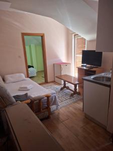 a room with a bed and a table and a sink at Apartmani Lazić No 11 in Gracanica