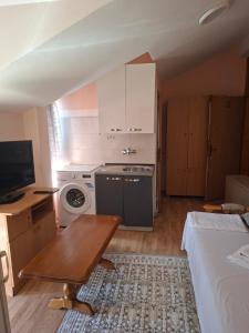 a small room with a kitchen and a bed and a table at Apartmani Lazić No 11 in Gracanica
