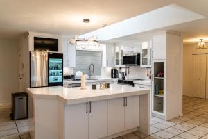 a kitchen with white cabinets and a large island at Mountain Retreat Hope in Hope