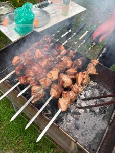 a bunch of meat on skewers cooking on a grill at Guest house Nano in Martvili