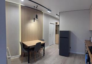 a kitchen with a table and chairs and a refrigerator at Dream 71 in Lutsk