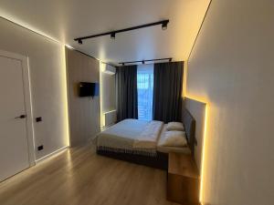 a bedroom with a bed and a window with lights at Dream 71 in Lutsk