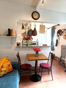 a kitchen with a table and chairs and a clock at Studio in Barbéns, Miranda do Corvo - Casa 99 in Miranda do Corvo