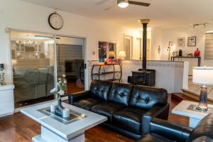 a living room with a leather couch and a stove at Mountain Retreat Hope in Hope +21 photos