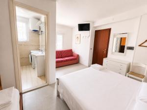 a bedroom with a bed and a red couch in it at Anthea - Timavo apartment 2 in Lignano Sabbiadoro