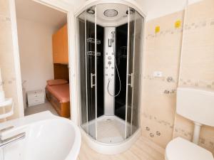 a bathroom with a shower with a sink and a toilet at Anthea - Timavo apartment 2 in Lignano Sabbiadoro