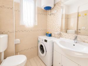 a bathroom with a washing machine and a sink at Anthea - Timavo apartment 2 in Lignano Sabbiadoro +2 photos