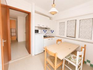 a kitchen with a wooden table and chairs in a room at Anthea - Timavo apartment 2 in Lignano Sabbiadoro