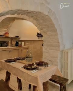 a table in a kitchen with a stone archway at Trullo Galileo in Alberobello