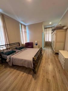 a bedroom with a bed and wooden floors and windows at Ninika B&B Utsera in Oni