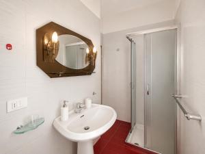 a white bathroom with a sink and a shower at Anthea- Paluzza Apartment & Parking in Lignano Sabbiadoro