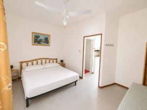 a white bedroom with a bed and a mirror at Anthea- Paluzza Apartment & Parking in Lignano Sabbiadoro
