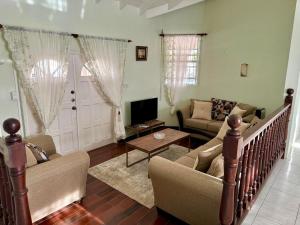 a living room with a couch and a tv at Tropical Retreat - by ZenBreak in Saint Peter
