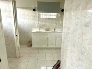 a white bathroom with a sink and a mirror at Tropical Retreat - by ZenBreak in Saint Peter +4 photos