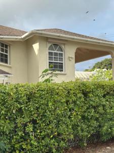a house with a hedge in front of a building at Tropical Retreat - by ZenBreak in Saint Peter