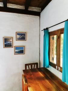 a dining room with a wooden table and a window at Las Cabañas de la Iguana in Ayampe