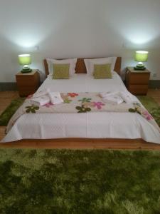 a bedroom with a large bed with towels on it at Alojamento Local F&B in Guimarães