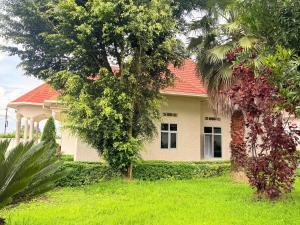 a house with a red roof on a green yard at Volcanoes Stay Musanze in Kigali +9 photos