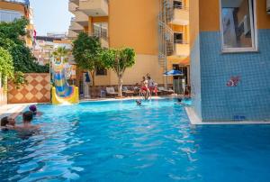 a group of people swimming in a swimming pool at Kleopatra Ikiz Hotel in Alanya