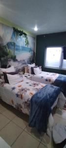 a group of beds in a room with a mural at Gaia Hydro-Spa and Guest House in Cape Town