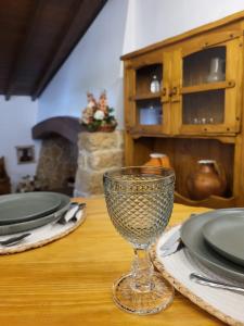 a wine glass sitting on a table with plates at Moinho da Quinta da Esperança in Ourém