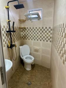 a bathroom with a toilet and a sink at cosy house in Kobuleti +3 photos