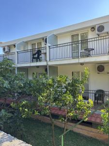 an apartment building with a balcony and trees at Vila Stanisic in Čanj +17 photos
