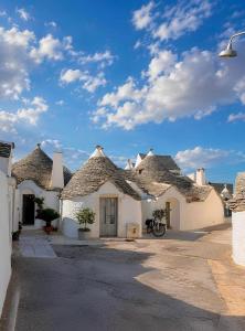 a group of white buildings with roofs at Trullo Galileo in Alberobello