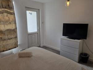 a bedroom with a bed and a flat screen tv at Kingfield Boutique Hotel in Sheffield