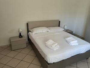 a bedroom with a bed with white sheets and towels at SunFra Retreat in Belvedere Marittimo