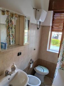 a bathroom with a sink and a toilet and a window at SunFra Retreat in Belvedere Marittimo +12 photos