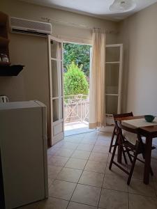 a kitchen with a table and a sliding glass door at Ta Adelfia in Pylos