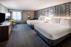 a hotel room with two beds and a flat screen tv at Cape Cod Family Resort and Parks in West Yarmouth